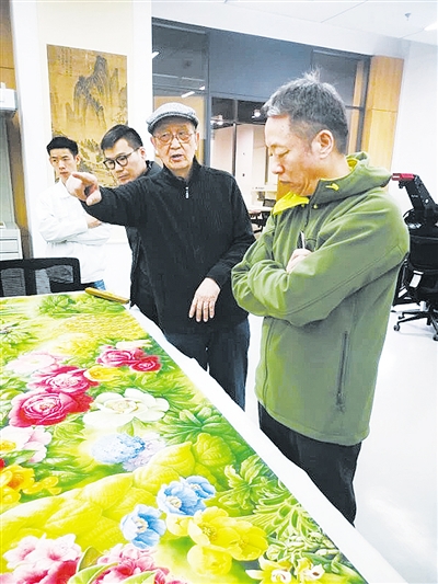 ◀导演李成才（右）与植物画家曾孝濂（右二）一起讨论纪录片同名画作。